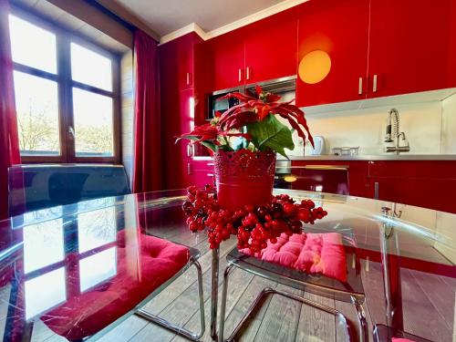 une cuisine avec des placards rouges et une table en verre dans l'établissement City Apartments by Malmedreams, à Malmedy