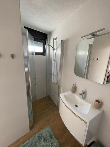 a white bathroom with a sink and a shower at Villa Laverna Annex in Novalja