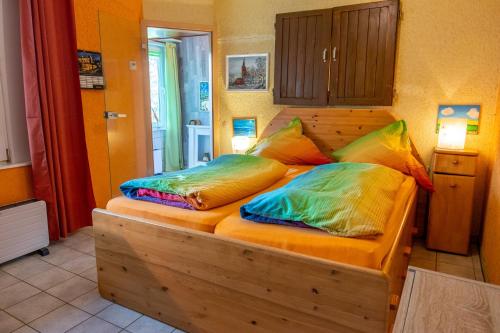 1 dormitorio con cama de madera y almohadas coloridas en Bungalow in Gristow, en Gristow