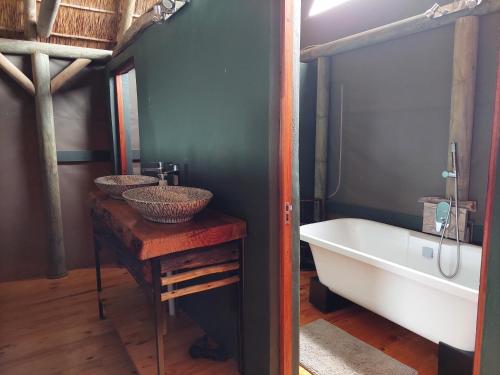 a bathroom with two sinks and a bath tub at Harmony Luxury Tents & Safari in Addo