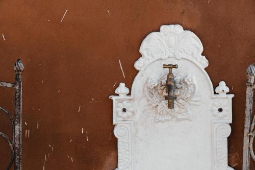 a cross on the side of a building with a fence at La pagliera in Agrigento
