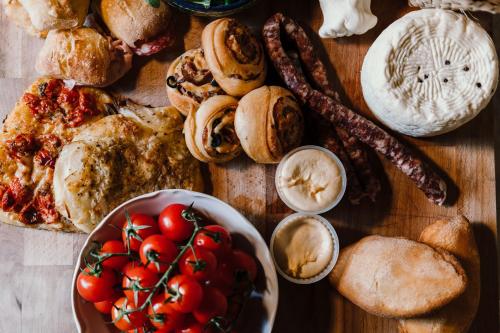 a table with a bunch of different types of bread and tomatoes at La pagliera in Agrigento