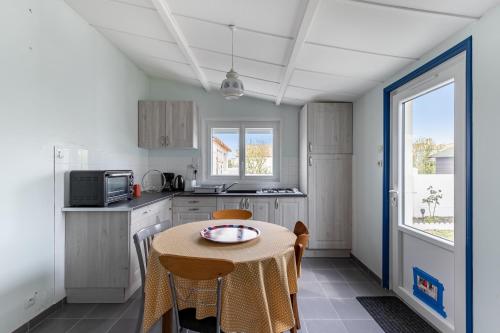 une petite cuisine avec une table et des chaises. dans l'établissement L'Argentine, Maison typique pour 5 a Saint Gilles-croix-de-vie, à Saint-Gilles-Croix-de-Vie