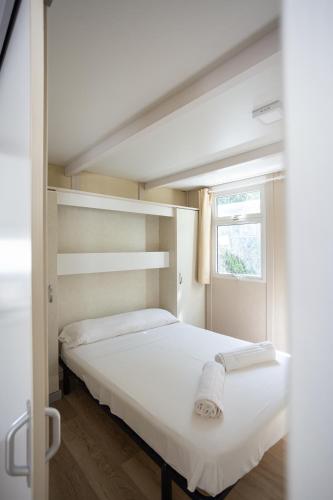a white bed in a room with a window at Complejo Turístico Los Escullos Cabo de Gata in Los Escullos