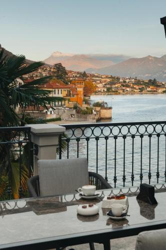 a table with two cups on top of a balcony at MUSA Lago di Como in Sala Comacina