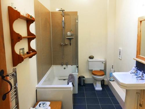 a bathroom with a tub and a toilet and a sink at Drovers Retreat in Llandrindod Wells