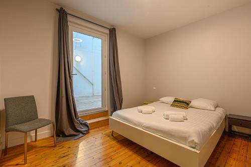 sypialnia z łóżkiem, oknem i krzesłem w obiekcie Le Patio - Bel Appartement de caractère hypercentre de Vannes w mieście Vannes