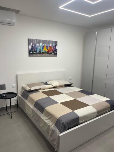 1 dormitorio con 1 cama con manta a cuadros en WHITE HOUSE, en Aci Catena