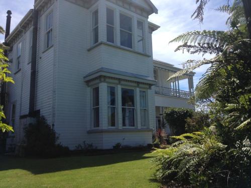 a white house with a large window on the side of it at Tripinn Modern Motels & Affordable Accommodation in Westport