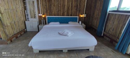 a bedroom with two beds in a room at Mango Valley Resort Ganpatipule in Ratnagiri