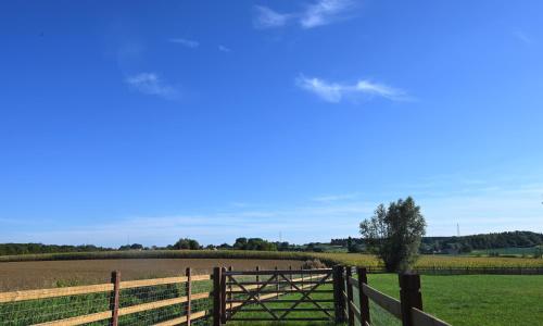a wooden fence in front of a field at De Sint-Antoniushoeve in Zonnebeke