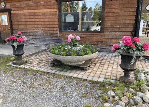 two vases filled with flowers in front of a house at Angsjöns Camping in Bjurholm