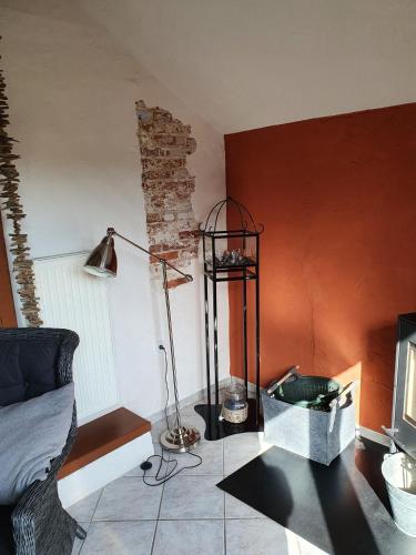 een woonkamer met een bank, een tafel en een lamp bij Ferienhaus Auszeit am Dollart 25195 in Bunde