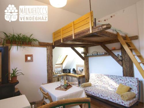 Habitación con cama elevada, sofá y mesa. en Málnafröccs Vendégház Nagymaros en Nagymaros