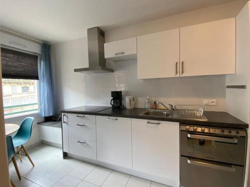 a kitchen with white cabinets and a counter top at Montpellier : Appartement Cosy et très fonctionnel in Montpellier