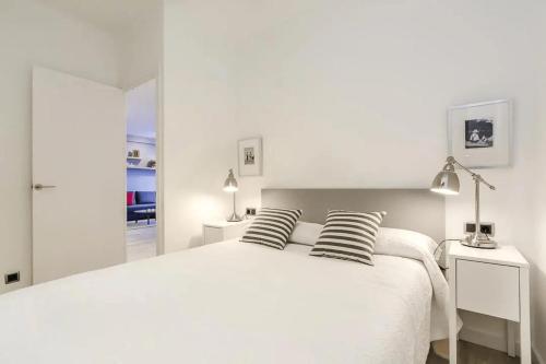 a white bedroom with a large white bed with two pillows at 51SAM1021 - Modern apartment near Montjuic in Barcelona