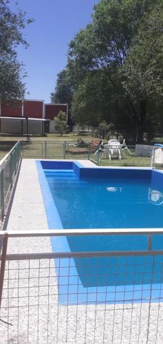 a blue swimming pool with a fence around it at Del Carmen in Villa Giardino