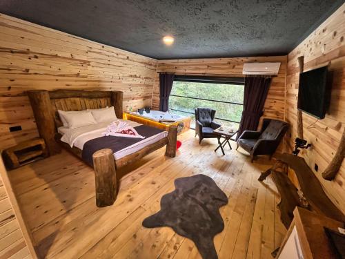 a bedroom with a bed in a log cabin at Medi Soho Bungalov in Rize