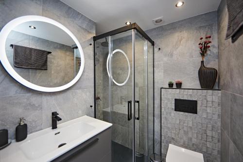 een badkamer met een douche, een wastafel en een spiegel bij Apartamento Panda House in Playa del Inglés