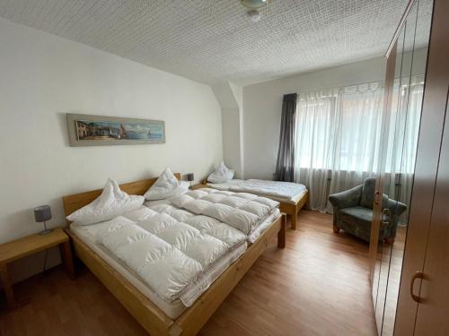 1 dormitorio con 1 cama grande y 1 silla en "Altes Haus" am Kurpark in den Bergen, en Zorge