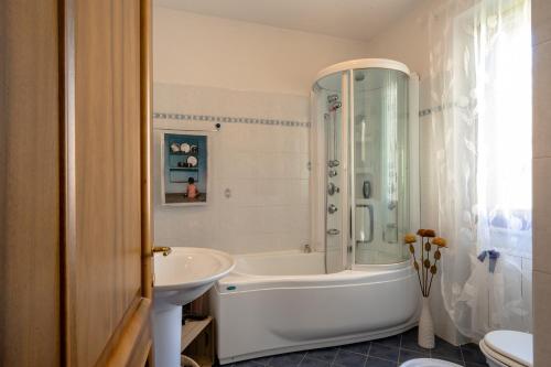 La salle de bains blanche est pourvue d'une baignoire et d'un lavabo. dans l'établissement Casa Furia, à Ponte della Venturina
