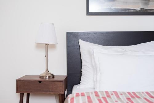 a bedroom with a bed and a lamp on a night stand at St. George Apartments in Prague