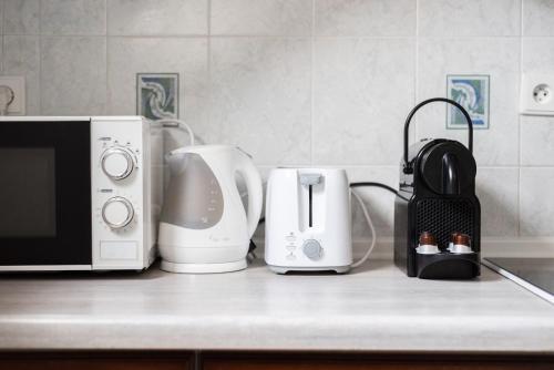 a kitchen counter with a microwave and appliances on it at St. George Apartments in Prague