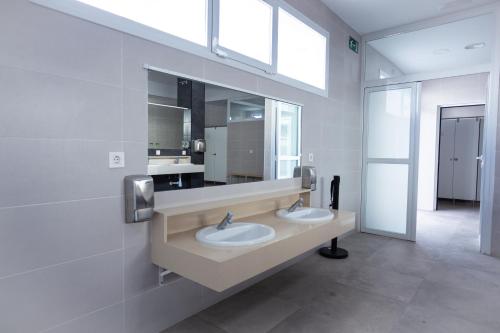 baño con 2 lavabos y espejo grande en Complejo Turístico Los Escullos San Jose, en Los Escullos