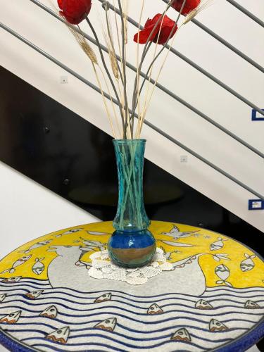 a vase with flowers in it sitting on a table at Palazzo Della Guardia in Vietri sul Mare