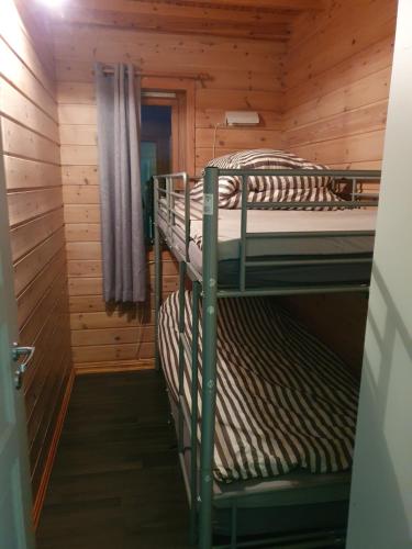 a room with two bunk beds in a cabin at Vestavind hytter og rom AS in Vigra