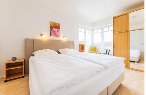 a large white bedroom with a large bed with white sheets at Villa Judith App. 2 Seepark in Binz