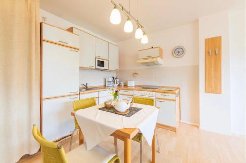 a kitchen with a table and chairs in a room at Villa Judith App. 2 Seepark in Binz