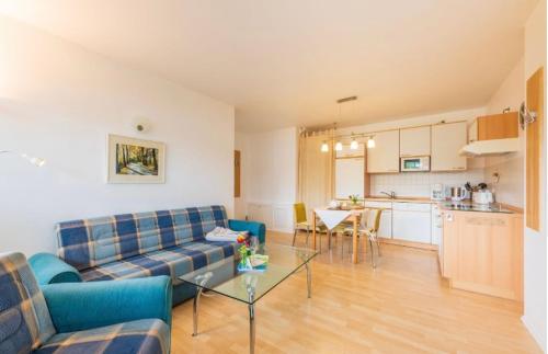 a living room with a couch and a table and a kitchen at Villa Judith App. 2 Seepark in Binz