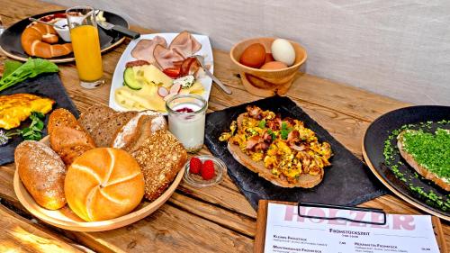 a wooden table topped with plates of breakfast foods at Ferienhaus Holzer in Weissensee