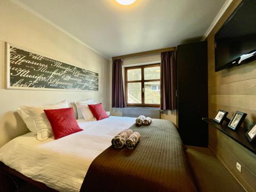 City Apartments by Malmedreams في مالميدي: غرفة نوم مع سرير مع اثنين من الحيوانات المحشوة عليه