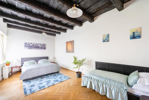 two beds in a large room with wooden floors at St. George Apartments in Prague