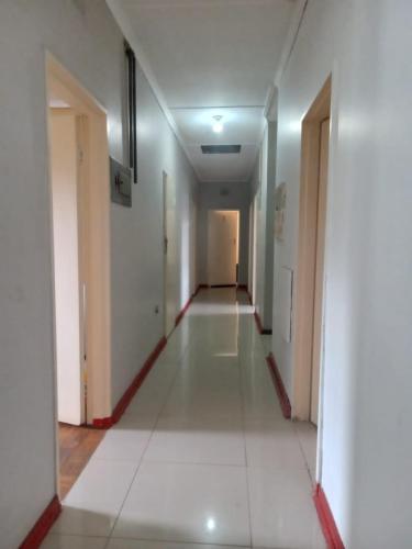 an empty hallway in a building with white walls and floors at FARANAS in Pietermaritzburg