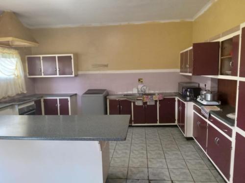 a kitchen with brown cabinets and a counter top at FARANAS in Pietermaritzburg