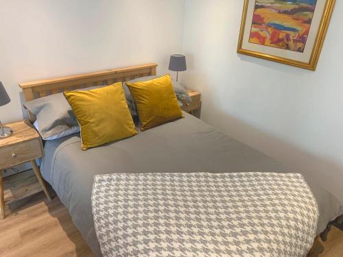 a bedroom with a bed with two yellow pillows at Hidden Well Studio in Hannington