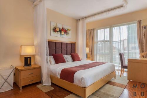 a bedroom with a large bed and a window at Lenana Suites in Nairobi