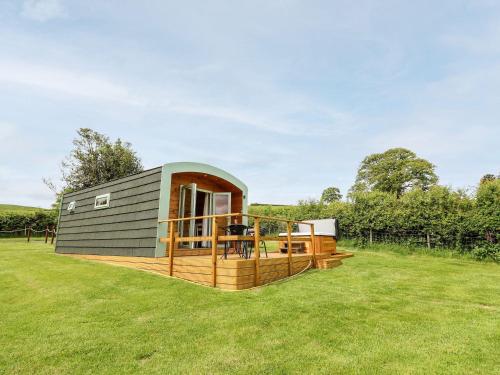 ein winziges Haus mit einer Terrasse auf einem Feld in der Unterkunft Hwyl in Abbey-Cwmhir