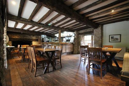 ein Esszimmer mit Holztischen und Holzstühlen in der Unterkunft Hidden Well Studio in Hannington