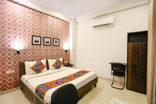 um quarto com uma cama e uma parede em FabHotel Novel Suites em Nova Deli