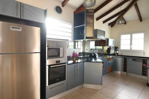 a kitchen with a stainless steel refrigerator and appliances at 972D3 - Villa Tamarin 240m2 vue panoramique in Rivière-Salée