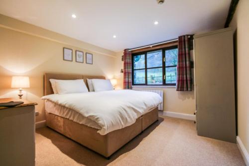 a bedroom with a large bed and a window at Kestrel Cottage in Builth Wells