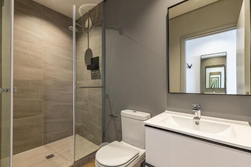 a bathroom with a toilet and a sink and a mirror at One Thibault Apartments by ITC Hospitality in Cape Town