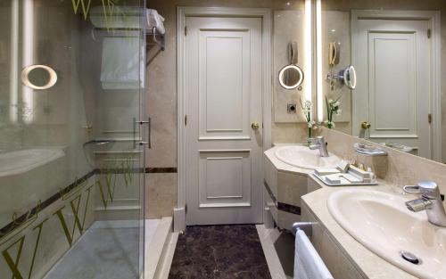 a bathroom with two sinks and a glass door at Wellington Hotel & Spa Madrid in Madrid
