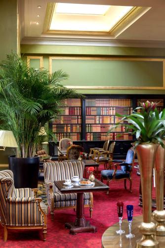 a library with chairs and tables and books at Wellington Hotel & Spa Madrid in Madrid