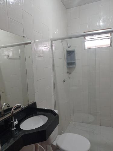a white bathroom with a sink and a toilet at Recanto das Palmeiras Alter do Chão in Alter do Chao