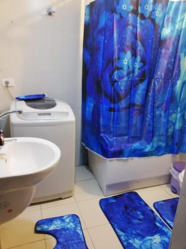 a bathroom with a toilet and a blue shower curtain at Comfortable studio in madinaty compound B11 in Madinaty